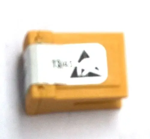Gelber Kodierstecker mit einer kleinen weißen Kennzeichnung, möglicherweise von Daikin, auf einem weißen Hintergrund.
